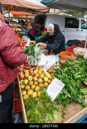 Femme vendant des produits cultivés localement sur le marché de Kalamata, Messinia, Péloponnèse du Sud, Grèce. Banque D'Images