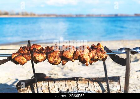 Cuisson de la viande de barbecue sur la plage. Cuisine, été, plage et loisirs concept - barbecue grill sur la plage d'été Banque D'Images