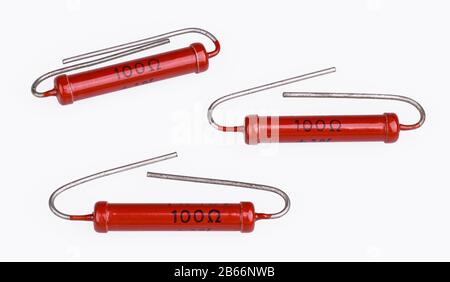 Résistances de puissance en carbone cylindriques avec fils de plomb tordus sur fond blanc. Groupe de composants électriques passifs à deux bornes rouges. Electrotechnique. Banque D'Images