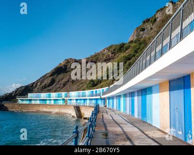 Une rangée de cabanes de plage colorées à Meadfoot, Torquay Royaume-Uni Banque D'Images