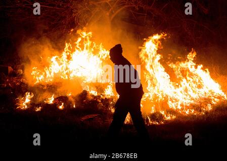 Homme brûlant de l'herbe sèche sur un terrain vacant, Gikuyu Close, près de l'hippodrome, Ngong Road, Nairobi, Kenya, 11 mars 2019 Banque D'Images