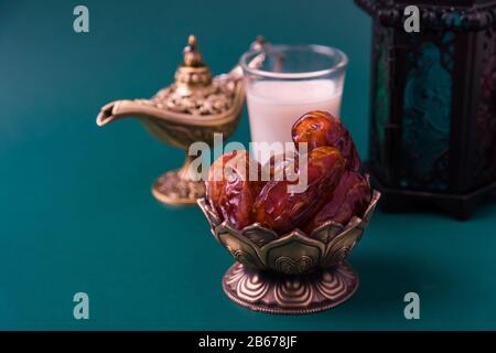 Ramadan Kareem concept alimentaire à jeun, dates de la plaque de bronze, lait, et décoration de la lanterne Aladdin lampe, eid festival religieux musulman arabe sur un gr sombre Banque D'Images