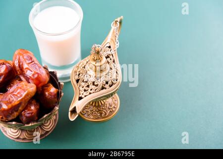 Ramadan, dates dans le bol doré, Le Lait, arabian Aladdin feu de style vintage sur fond vert noir Banque D'Images