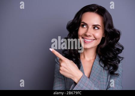 Gros plan photo de la belle dame regardant son doigt sur l'espace de copie montrant promo costume blazer veste isolé sur fond gris Banque D'Images