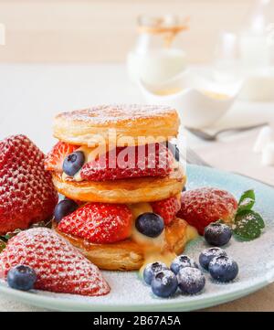 Mille Feuille, disques de pâte feuilletée avec fraises géantes et bleuets avec crème au citron. Recette Gordon Ramsay. Délicieux dessert français avec été b Banque D'Images