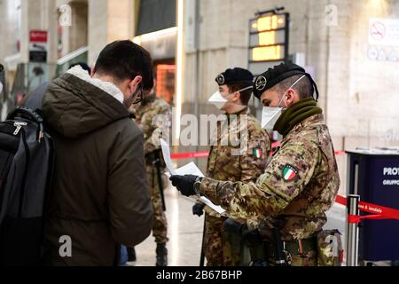 Milan, Italie - 10 mars 2020: Le personnel militaire italien et les policiers portant des masques de protection vérifient les passagers au départ de la gare centrale de Stazione car de nouvelles mesures restrictives sont prises pour contenir l'éclosion de Coronavirus COVID-19 crédit: Piero Cruciatti/Alay Live News Banque D'Images