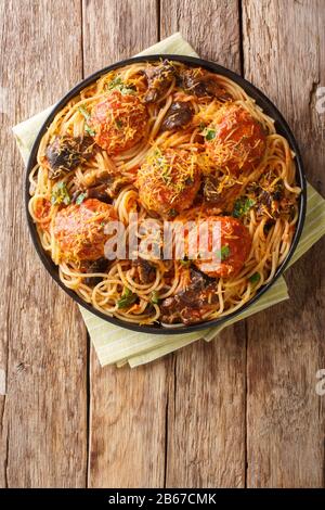 Boulettes de viande italiennes avec un plat latéral de spaghetti aux champignons et au cheddar près dans une assiette sur la table. Vue verticale du dessus Banque D'Images
