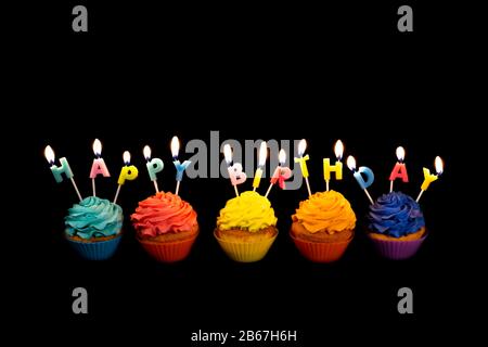 Bannière avec des cupcakes Colorés et des bougies épeler Joyeux anniversaire isolé sur fond noir. Bannière de concept anniversaire monochrome avec cinq cupcake A Banque D'Images