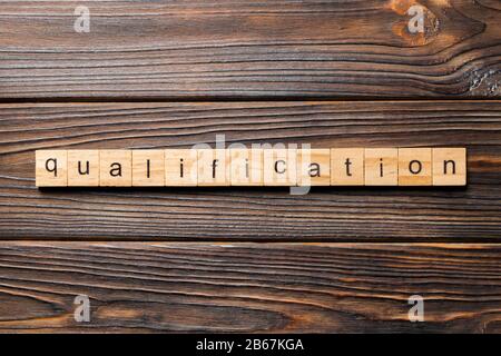 Mot de qualification écrit sur la cale en bois. qualification texte sur table, concept. Banque D'Images