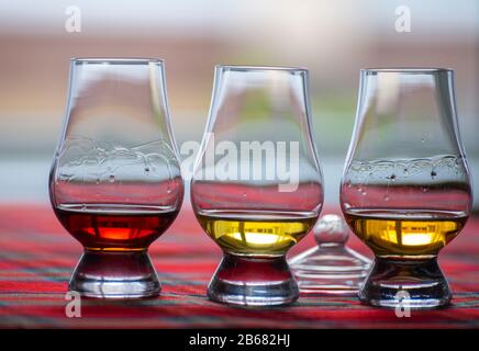 Lunettes spéciales en forme de tulipe avec couvercle pour la dégustation de whisky écossais sur la distillerie en Ecosse, au Royaume-Uni et au tartan rouge Banque D'Images