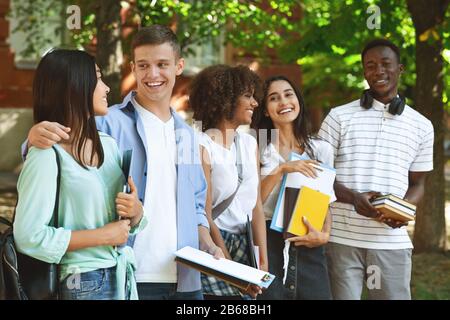 Groupe d'étudiants internationaux se moquant ensemble en plein air sur le campus de l'université Banque D'Images