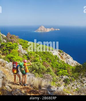 Deux randonneurs marchent le long du sentier Lycien Way en Turquie et admirent une vue magnifique sur l'île dans une mer méditteraneenne Banque D'Images