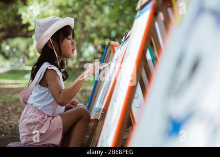 petite fille dessin pendant les vacances dans le parc Banque D'Images