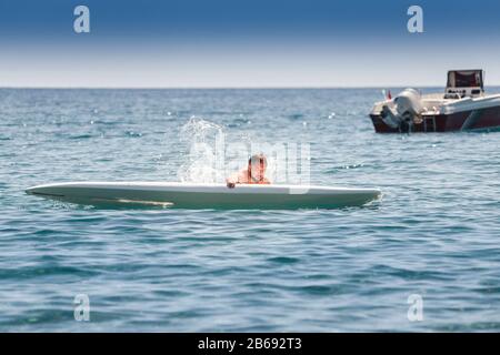débutant surfeur novice tombe du conseil pendant l'entraînement en mer Banque D'Images