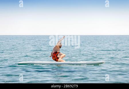 débutant surfeur novice tombe du conseil pendant l'entraînement en mer Banque D'Images