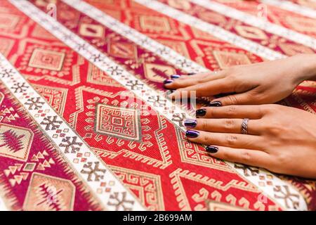 Mains féminines avec manucure sur le modèle national turc sur les Tissus Tablecloth Banque D'Images