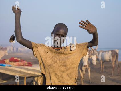 Un garçon de la tribu Mundari imite la position des cornes de vache, son favori, l'Équatoria central Terekeka, au Soudan du Sud Banque D'Images