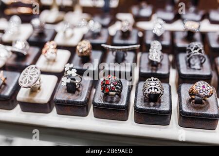 Divers anneaux d'or avec des pierres précieuses dans la boutique de bijoux, fenêtre de gros plan Banque D'Images