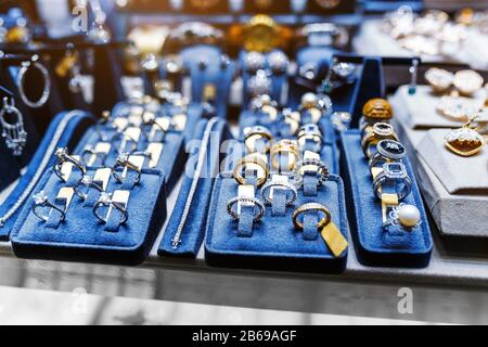 Divers anneaux d'or avec des pierres précieuses dans la boutique de bijoux, fenêtre de gros plan Banque D'Images