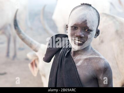 Un jeune garçon souriant de la tribu Mundari couvert de cendres pour repousser les mouches et les moustiques dans un camp de bétail, l'Equatoria central, Terekeka, Soudan du Sud Banque D'Images