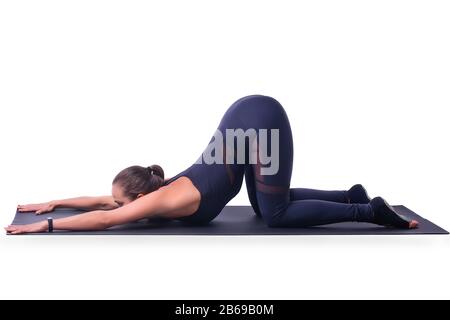 Belle fille athlétique isolée sur un fond blanc faisant de l'exercice de flexion allongé sur le sol. Yoga concept de mode de vie sain Banque D'Images