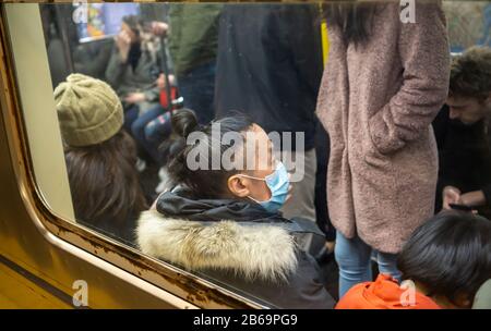 Un homme porte un masque chirurgical sur le métro de New York le samedi 7 mars 2020. De nombreuses personnes portent le masque comme protection contre l'éclosion de coronavirus. (© Richard B. Levine) Banque D'Images