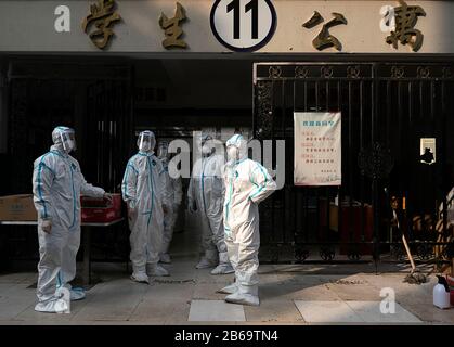 (200310) -- WUHAN, le 10 mars 2020 (Xinhua) -- des volontaires sont vus à la porte du centre de réadaptation du Wuhan Vocational College of Software and Engineering à Wuhan, dans la province de Hubei en Chine centrale, le 10 mars 2020. Les patients atteints de coronavirus guéris qui avaient été libérés de l'hôpital étaient tenus d'effectuer une quarantaine de 14 jours dans des endroits désignés pour l'observation médicale. Le centre de réadaptation, converti du dortoir du Wuhan Vocational College of Software and Engineering, a reçu plus de 600 patients guéris de coronavirus qui ont été libérés de l'hôpital lundi. Banque D'Images