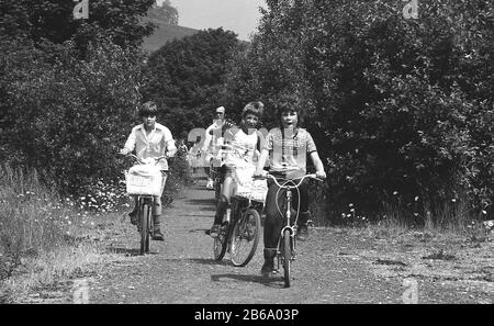 Années 1970, historique, les jeunes s'amusent à vélo, à cheval sur un chemin de gravier à travers la campagne rurale, Angleterre, Royaume-Uni. Banque D'Images