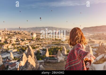 Une femme voyage à travers Cappadoce à l'arrière-plan d'un spectacle de montgolfière en Turquie Banque D'Images