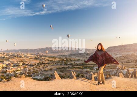 Une femme voyage à travers Cappadoce à l'arrière-plan d'un spectacle de montgolfière en Turquie Banque D'Images