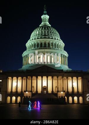 Les gens en costumes éclairés près du bâtiment du capitol. Banque D'Images