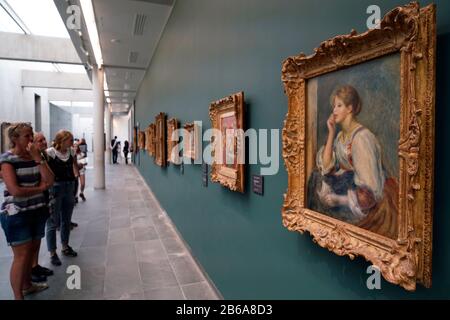 Les visiteurs qui apprécient la peinture de Renoir 'femme al la lettre' sont exposés au Musée l'Orangerie, Paris France Banque D'Images