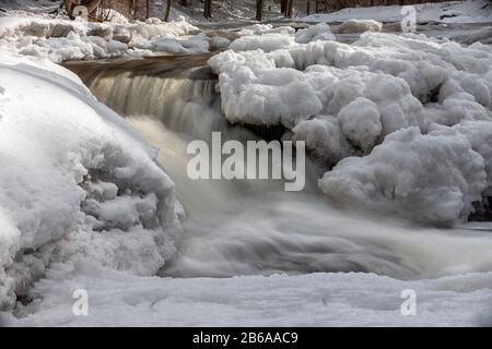 Les chutes d'Ocqueoc traversent la neige et la glace en hiver près de Rogers City dans le nord du Bas-Michigan Banque D'Images