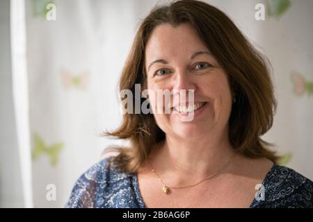 Gros plan portrait d'une femme souriante de 50 ans avec des cheveux bruns. Banque D'Images