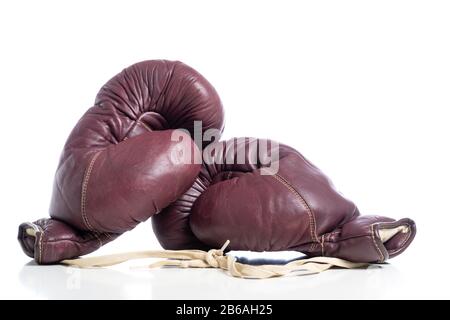 Une paire de gants de boxe vintage en cuir sur fond blanc Banque D'Images