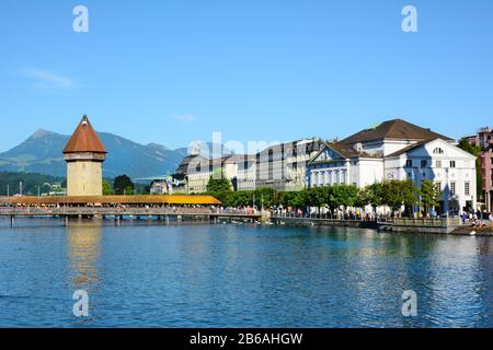 Lucerne, SUISSE - 3 JUILLET 2014 : pont de la Chapelle sur la rivière Reuss. Les montagnes, les hôtels et la gare sont en arrière-plan. Banque D'Images