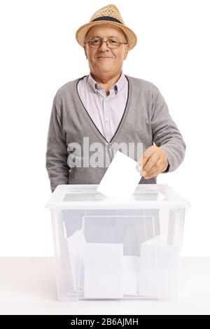 Homme âgé plaçant un papier de vote dans une boîte et regardant la caméra isolée sur fond blanc