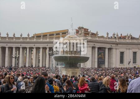 Cité du Vatican / Rome / Italie - 21 avril 2019 : foule de gens célébrant la messe de Pâques sur la place Saint-Pierre. Fontaine du Vatican au milieu. Banque D'Images