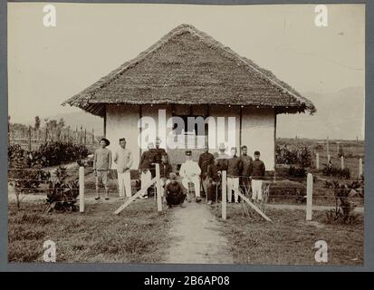 Officier avec baguette pour une maison, 1912 un officier néerlandais posant dans une chaise entourée d'employés pour une maison. Un signe est un texte écrit avec la date du 1er janvier 1912. Inge Coincé dans un album photo avec 87 photos sur la construction du Gajoweg dans le nord de Sumatra entre Bireuen et Takinguen entre 1903-1914. Fabricant : Photographe: Fabrication anonyme de lieux: Sumatra du Nord Date: 1912 Caractéristiques physiques: Gélatine de jour imprimé argent: Technique du papier: Gélatine de jour imprimé argent dimensions: Photo: H 138 mm × W 200 mmexpéditions de ToeliechtnNa à la conduite de Gajo et d'Alaslanden Banque D'Images