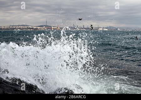 Surfez dans la baie de la Corne d'Or, les vagues s'écrasent sur les falaises côtières en arrière-plan d'Istanbul, en Turquie. Banque D'Images