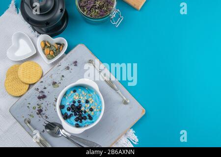 Fromage cottage avec confiture, bleuets frais et graines de citrouille dans un bol en céramique, à proximité. Petit déjeuner savoureux et sain Banque D'Images