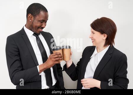 De nouveaux partenaires commerciaux qui toaster le café après avoir finalisé l'accord commercial, une femme caucasienne et un homme africain Banque D'Images