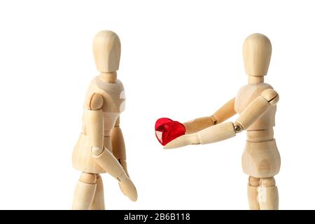 Deux figures en bois d'un mannequin, donnent un coeur rouge, isolé sur un fond blanc - images du thème concepts Amour et Saint Valentin. Synonyme Banque D'Images