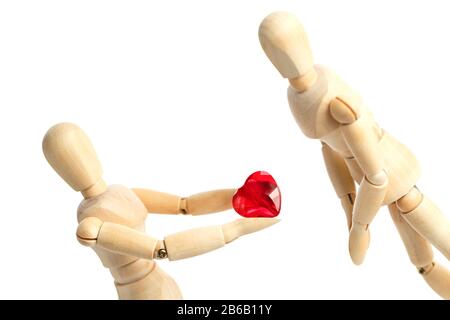 Deux figures en bois d'un mannequin, donnent un coeur rouge, isolé sur un fond blanc - images du thème concepts Amour et Saint Valentin. Synonyme Banque D'Images