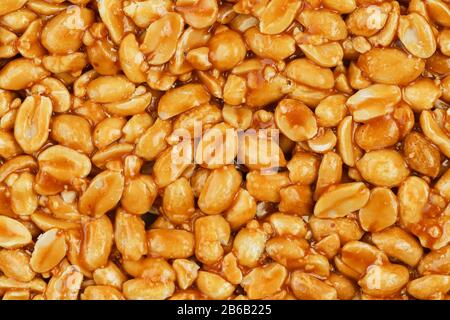 Kozinaki de haricots d'arachides dorés rôtis comme fond, texture. Prise de vue macro, gros plan. Banque D'Images
