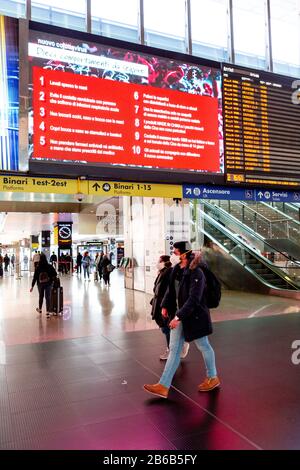 Rome, Italie, 10 Mars 2020. Éclosion de coronavirus. Les personnes portant un masque de visage marchent par une annonce d'hygiène publique à la gare Termini de Rome après que le Premier ministre Giuseppe Conte a déclaré que l'ensemble de l'Italie est devenue une "zone protégée" et que les gens ne devraient quitter leur maison que si cela n'est pas vraiment nécessaire et invoquer qu'ils maintiennent une "responsabilité". Crédit : Stephen Bisgrove/Alay Live News Banque D'Images