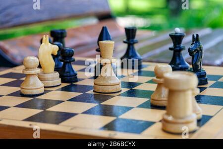 Échecs en bois sur le banc dans un parc. Banque D'Images