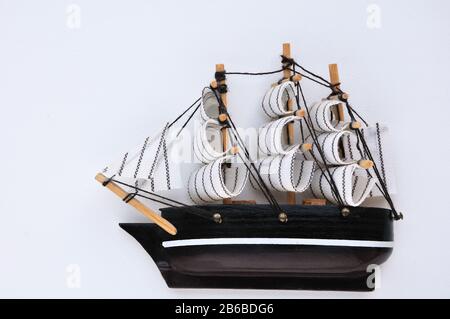 Miniature du voilier avec voiles blanches. Main-d'œuvre, elle est isolée sur un fond blanc Banque D'Images