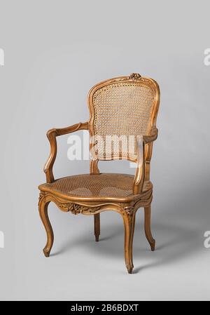 Fauteuil en noyer avec pattes placées en diagonale et dossier en forme de S et siège de la coupe de roseau de fleurs et de feuilles Avec coussin séparé série de huit pièces, PA-16851-A Armstoel (onderdeel van ameublement) van notenhout met tapis en zitting van riet. De gestrekte S-vormige, overhoeks geplaatste poten met profilering gaan zonder onderbreking in het zitraam over en zijn versierd met gestoken bloemen. De geschulpte voorzitregel heeft onder een profielrand gestoken bloemen en bladeren. De achter Banque D'Images