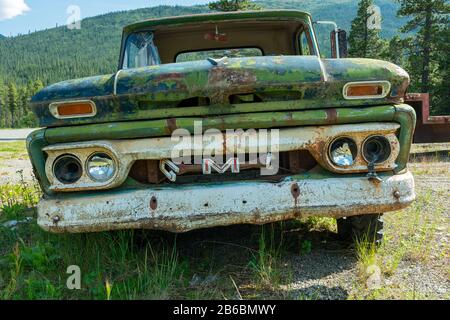 Cassiar, Colombie-Britannique, Canada - le 24 juillet 2017 : un ramassage vert rouillé au GMC dans un jardin en junkyard Banque D'Images
